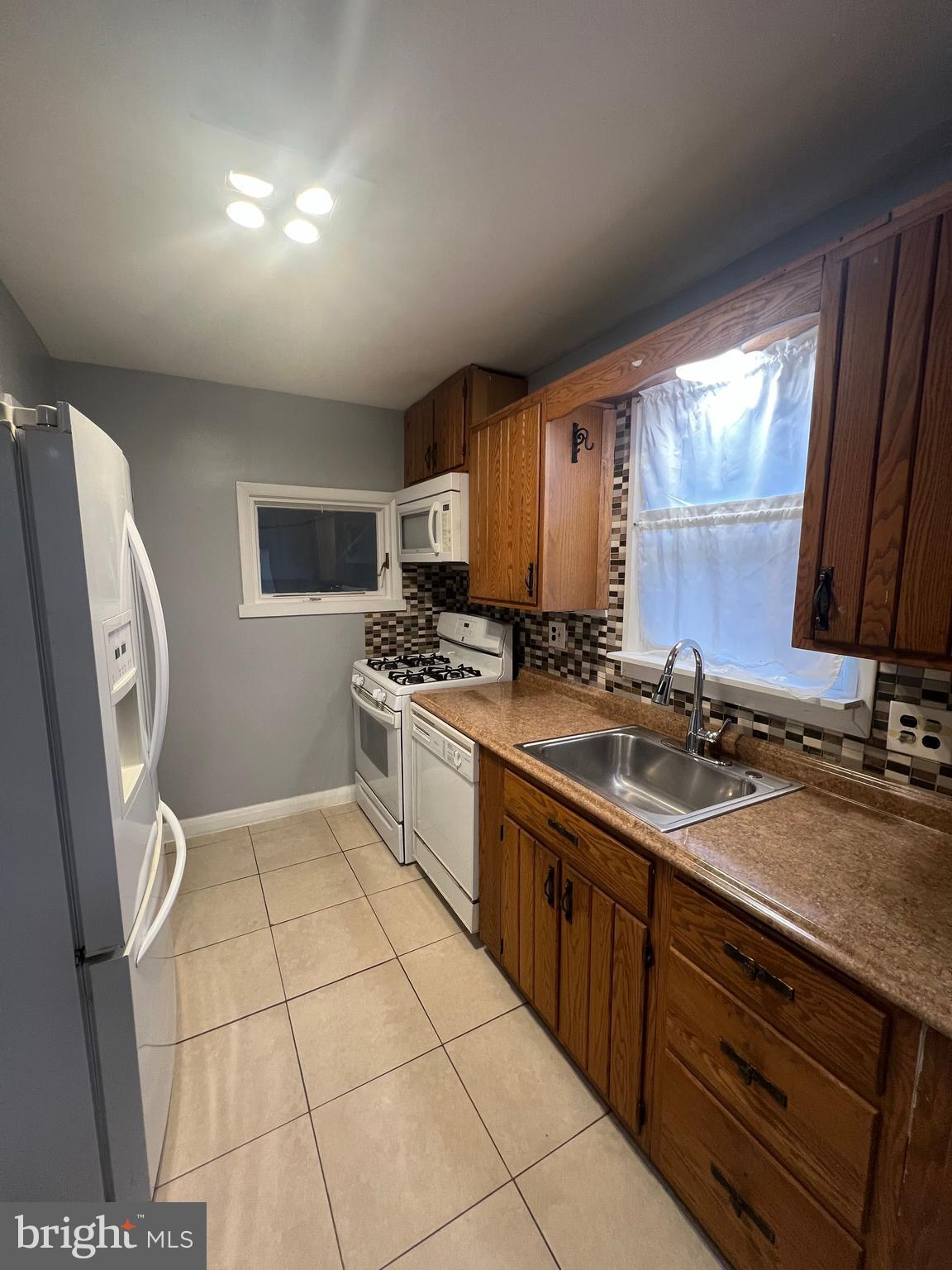 2518 Linwood Road Parkville, MD 21234 - Photo 8 of 27 a kitchen with a sink a stove cabinets and a window