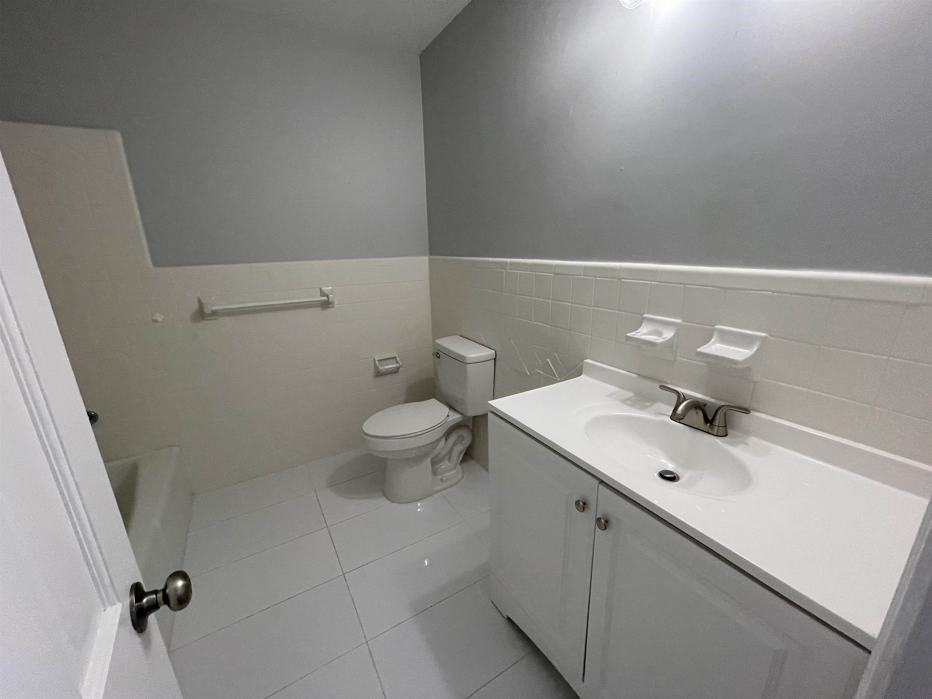 379 McElroy Road Memphis, TN 38120 - Photo 11 of 22 Bathroom featuring a white vanity with integrated sink, brushed nickel faucet, and white tile flooring