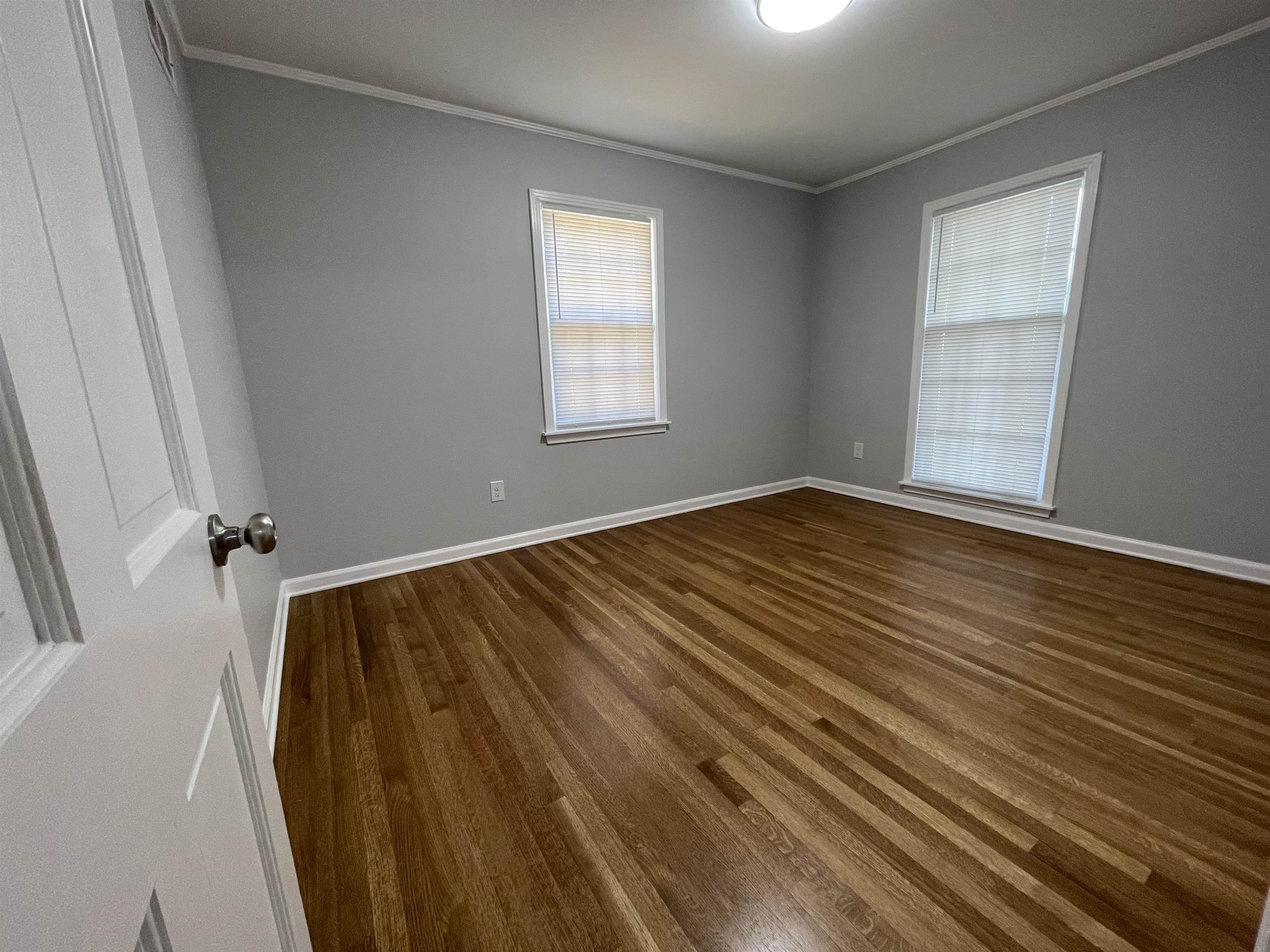 379 McElroy Road Memphis, TN 38120 - Photo 13 of 22 Spacious room featuring wood-finish flooring, two windows, and crown molding