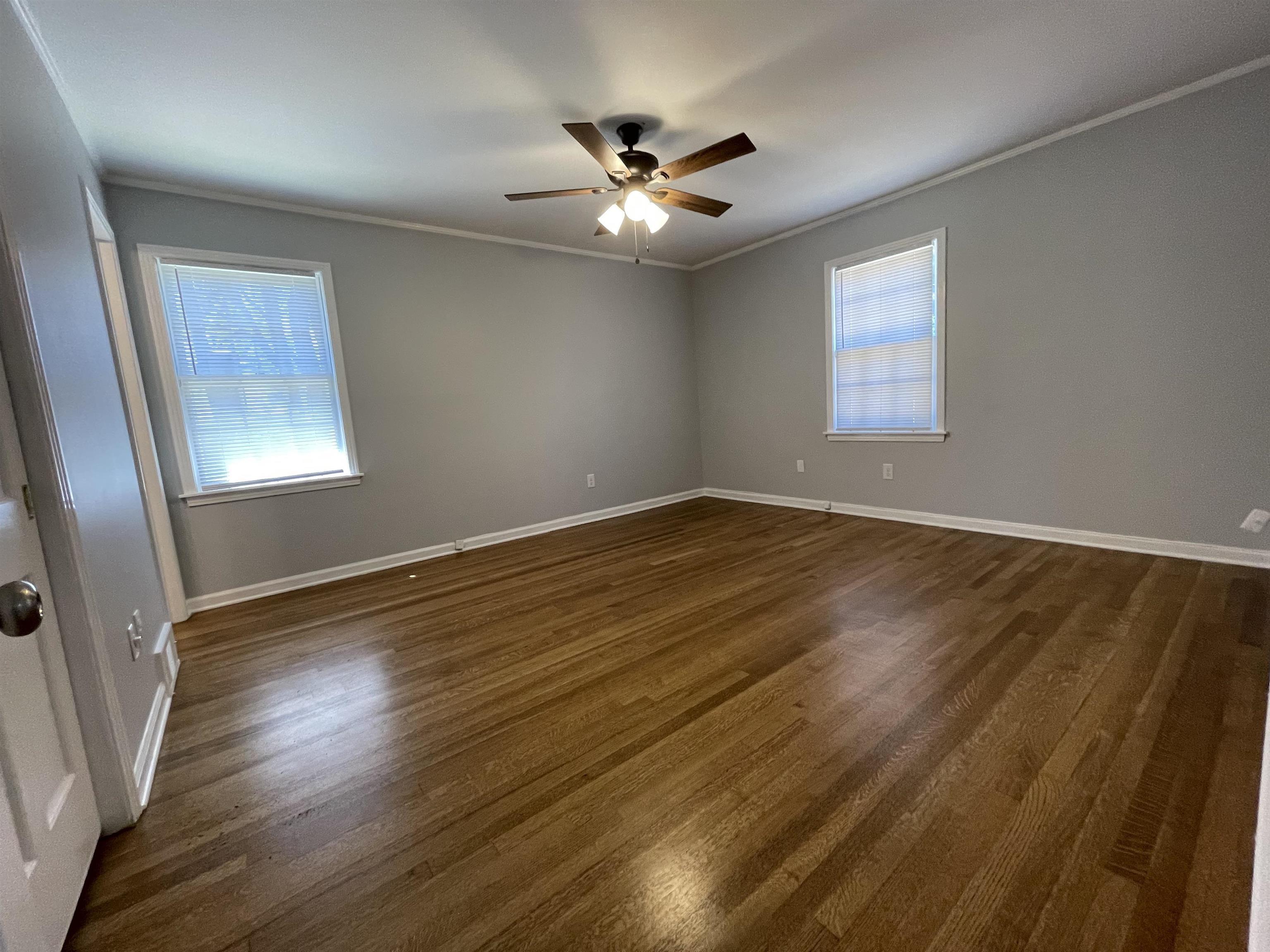 379 McElroy Road Memphis, TN 38120 - Photo 15 of 22 Spacious room featuring wood-finish flooring, two windows with blinds, a ceiling fan with integrated lighting, and crown molding
