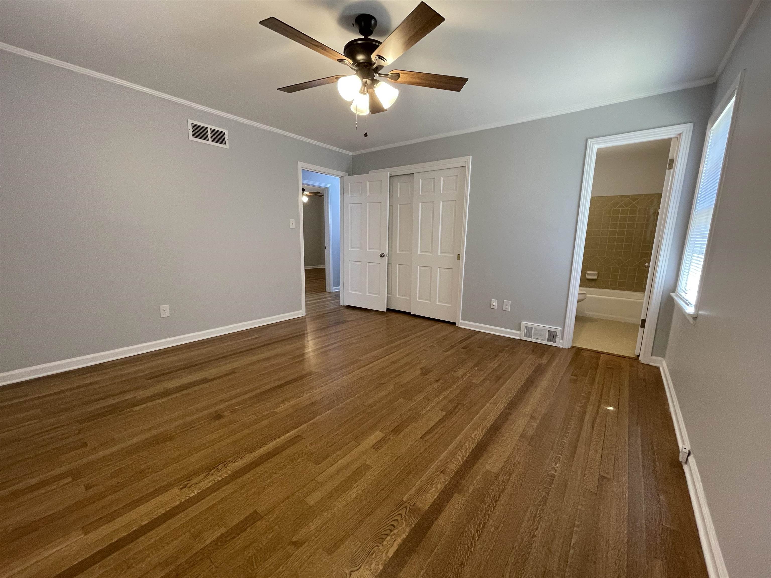 379 McElroy Road Memphis, TN 38120 - Photo 16 of 22 Hardwood flooring throughout, featuring light gray walls, white trim, and a ceiling fan with integrated lighting