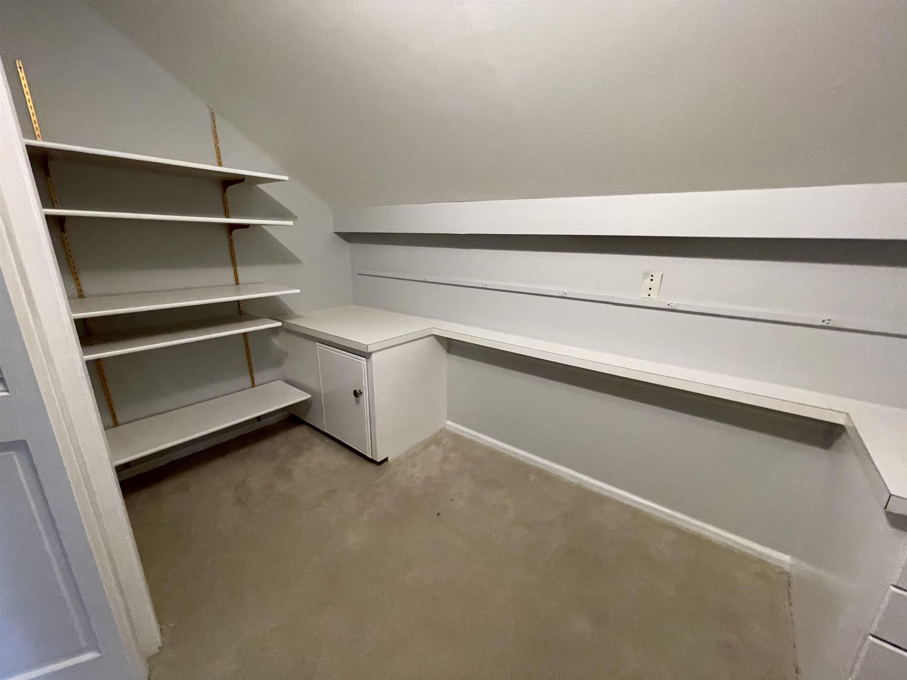 379 McElroy Road Memphis, TN 38120 - Photo 19 of 22 Attic space featuring wall-mounted adjustable shelving, built-in cabinetry with a countertop, recessed lighting, and neutral carpeting
