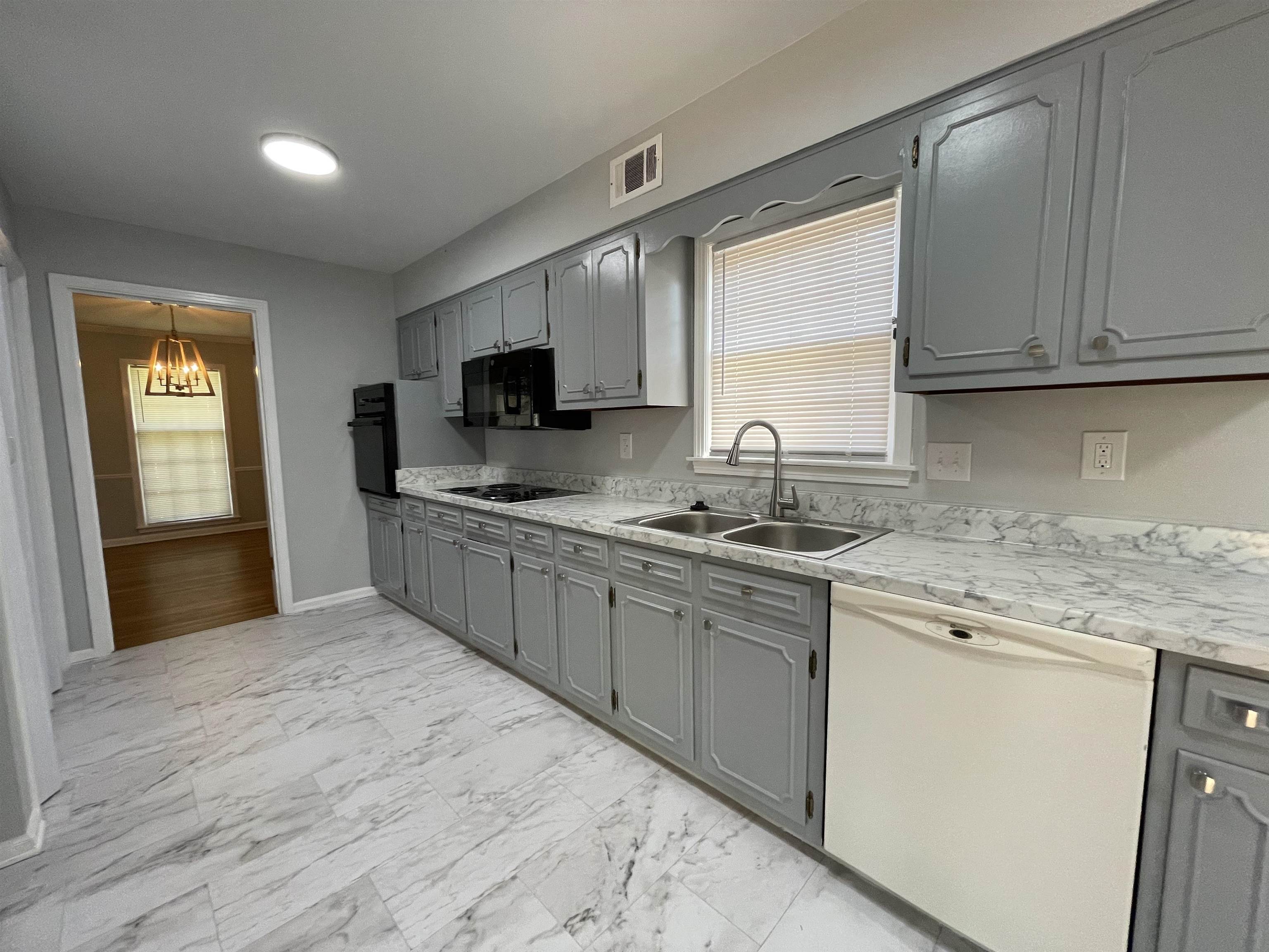 379 McElroy Road Memphis, TN 38120 - Photo 5 of 22 Kitchen featuring gray cabinetry, marble-patterned countertops, a dual basin stainless steel sink with a gooseneck faucet, black built-in appliances, and recessed lighting