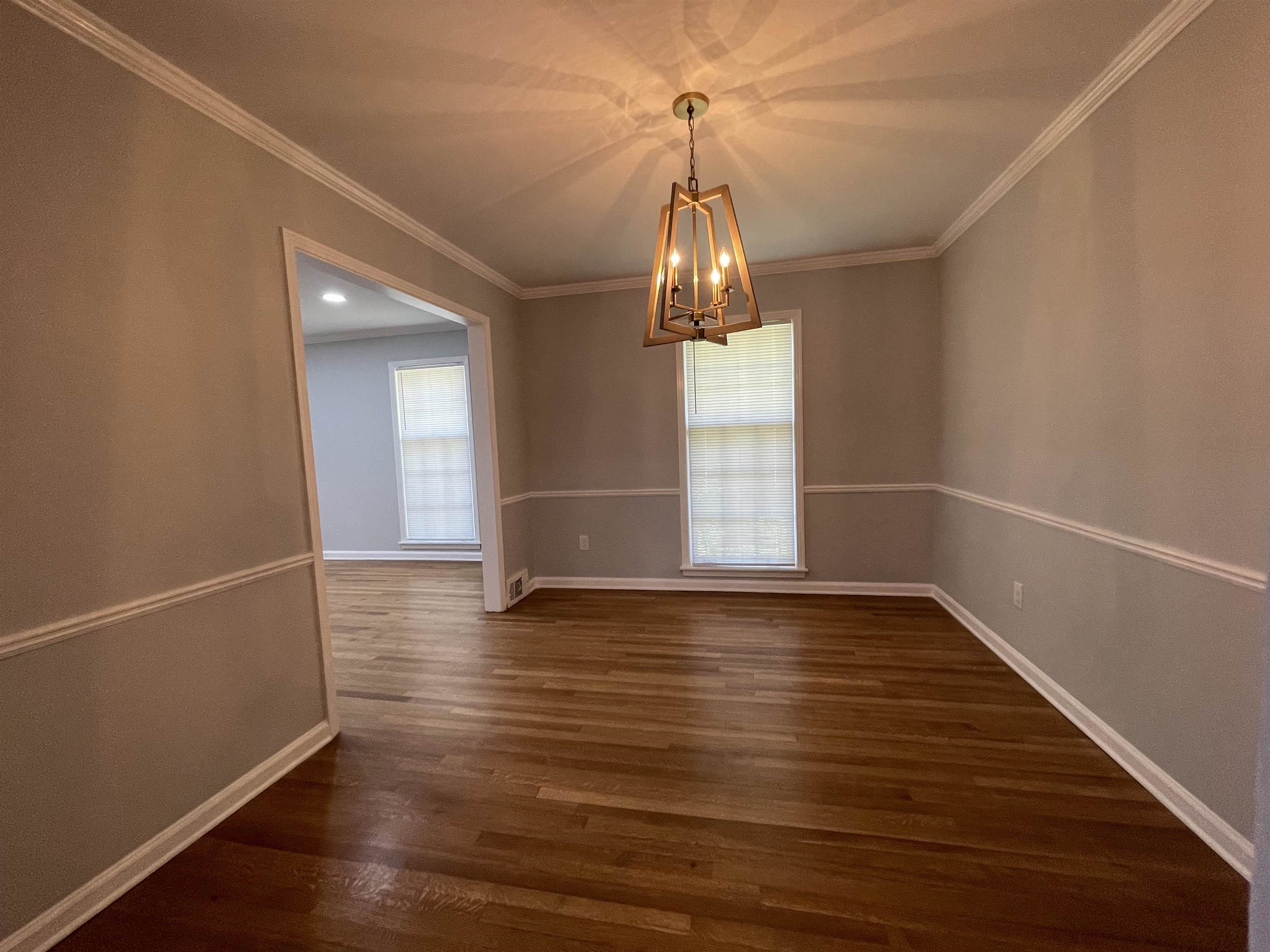 379 McElroy Road Memphis, TN 38120 - Photo 8 of 22 Room featuring wood-finish flooring, a modern geometric chandelier, and crown molding