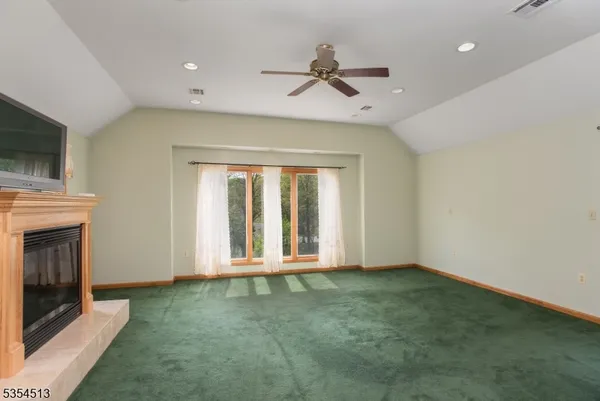a view of an empty room with a fireplace and a window