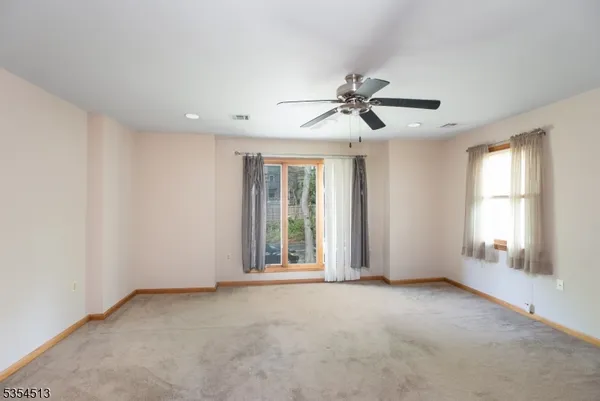 a view of a livingroom with a ceiling fan and window
