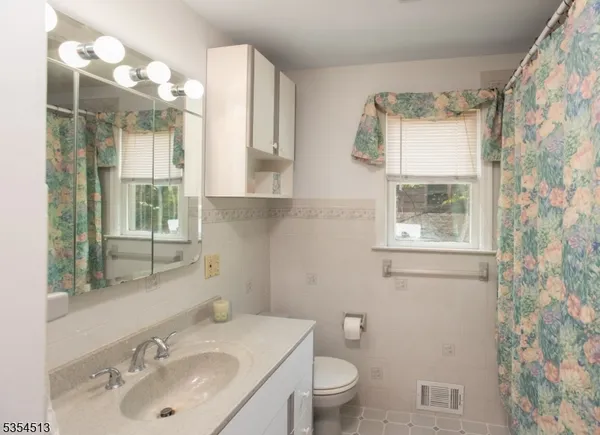 a bathroom with a sink vanity granite and toilet