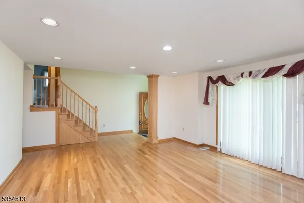 a view of an empty room with wooden floor