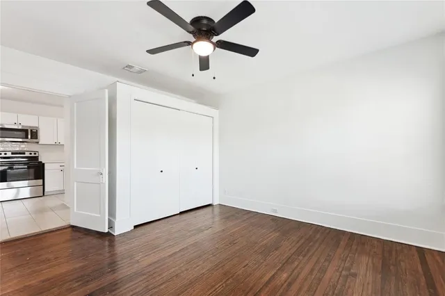 a view of a kitchen with wooden floor and a ceiling fan