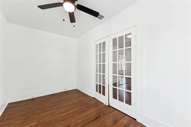 a view of a big room with wooden floor and windows