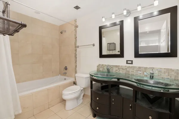 a bathroom with a sink a toilet a mirror and shower