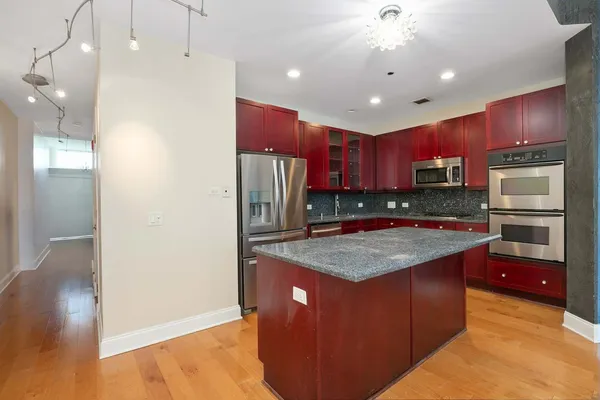 a kitchen with stainless steel appliances granite countertop a refrigerator a sink and a stove