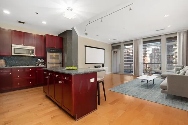 a kitchen with stainless steel appliances granite countertop sink stove and wooden cabinets