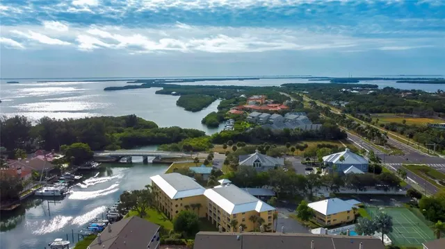 an aerial view of ocean and residential houses with outdoor space