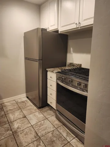a kitchen with granite countertop a stove and a refrigerator