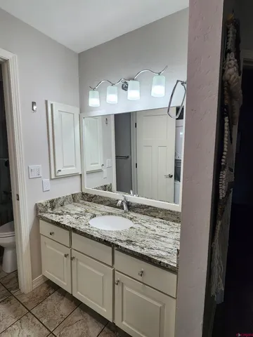 a bathroom with a granite countertop sink and a mirror