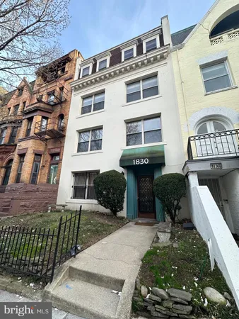 a front view of a building with a garden