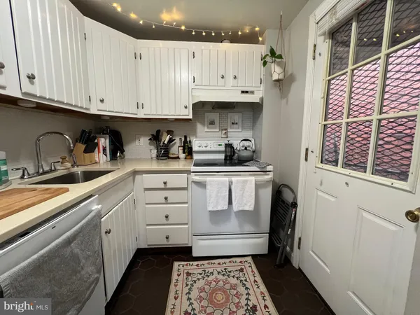 a kitchen with white cabinets and window