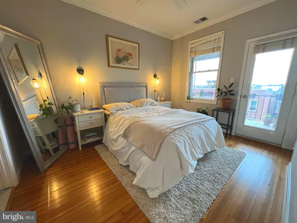 a bedroom with a bed and wooden floor