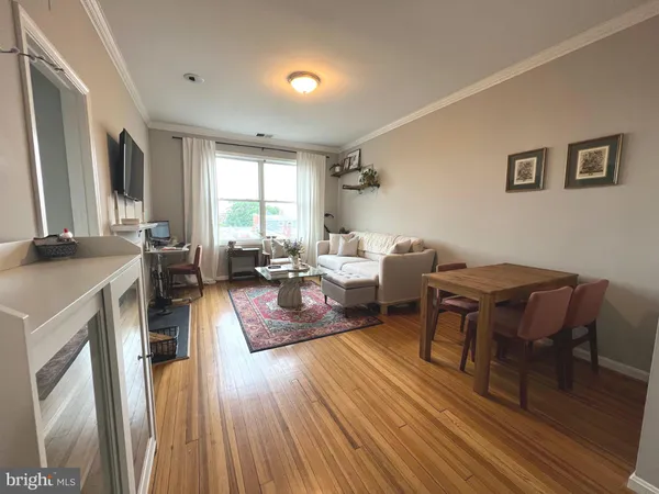 a living room with furniture a large window wooden floor and a fireplace