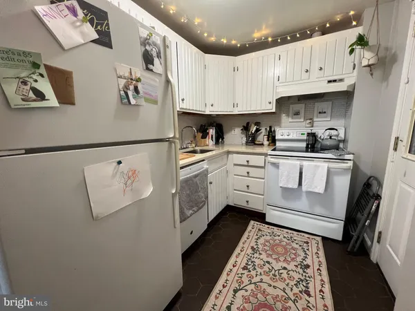 a kitchen with stainless steel appliances granite countertop a refrigerator sink and white cabinets