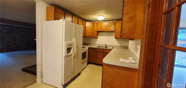 a kitchen with a refrigerator a stove top oven a sink and dishwasher