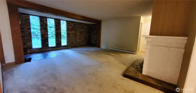 a view of a room with wooden floor and a window