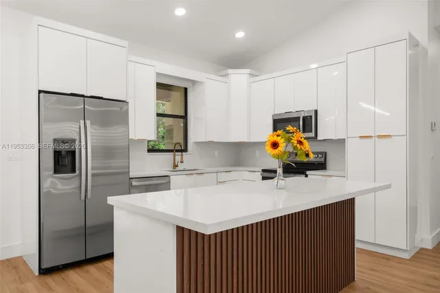 a kitchen with stainless steel appliances a sink stove and refrigerator