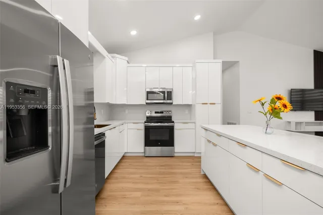 a kitchen with stainless steel appliances granite countertop a stove a sink and a refrigerator