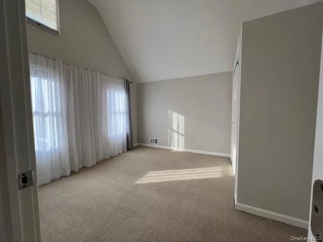 an empty room with closet and a hallway