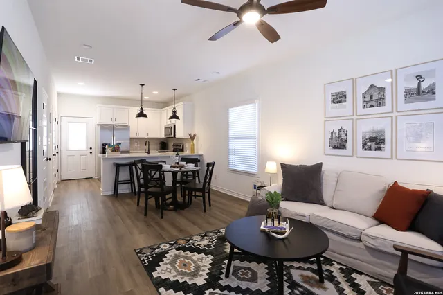 a living room with furniture kitchen view and a chandelier