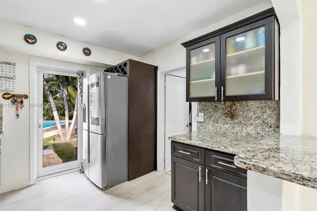 a kitchen with granite countertop a refrigerator and a sink