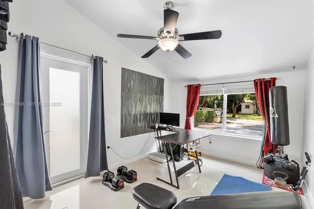 a living room with furniture a large window and gym equipment