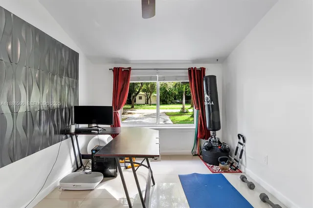 a view of a workspace with furniture and a window