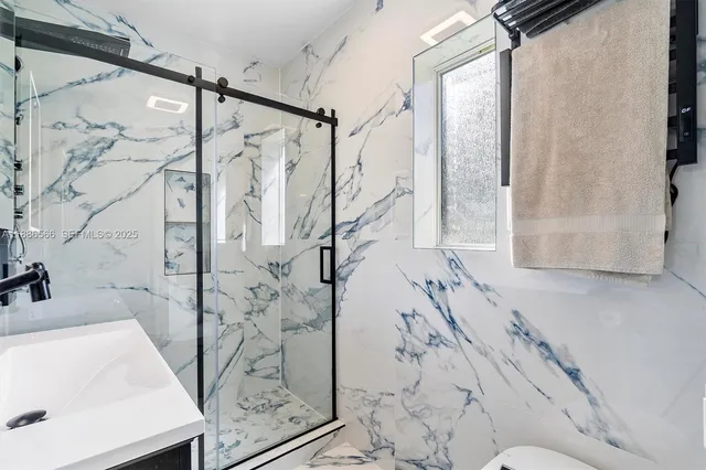 a bath tub sitting next to a white sink and a shower