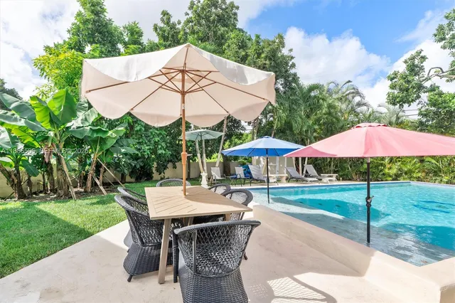 a view of patio with chairs and table under an umbrella