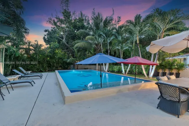 a view of a patio with a table and chairs under an umbrella
