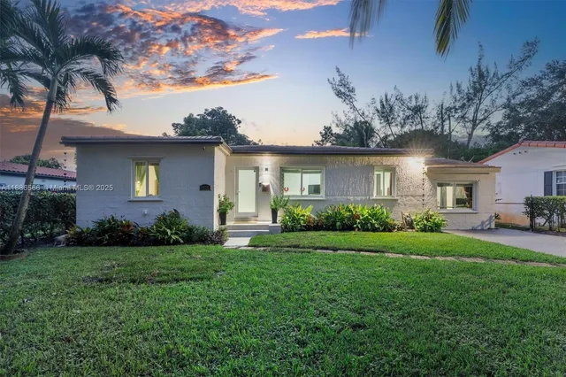 a front view of a house with a garden and yard