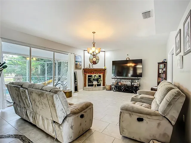 a living room with furniture a flat screen tv and a large window