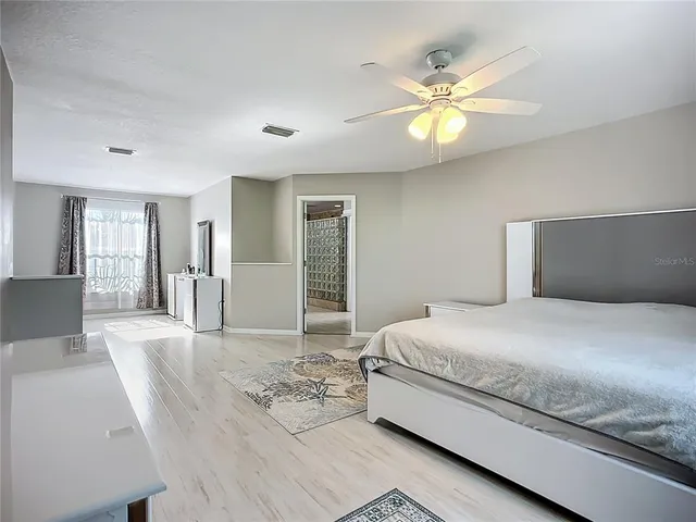 a spacious bedroom with a bed and a chandelier