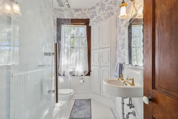 a bathroom with a sink a toilet and shower