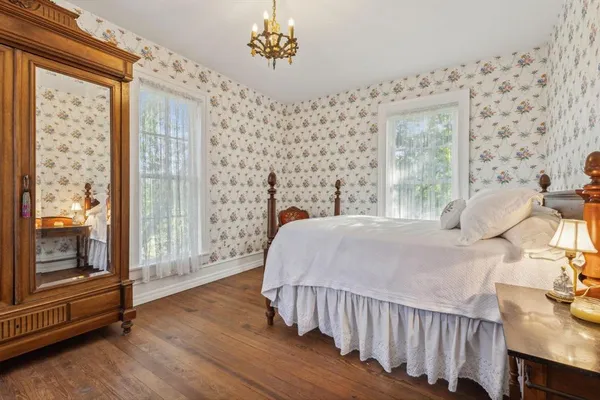 a bedroom with a bed mirror and window