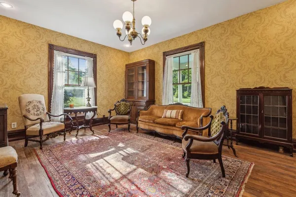 a living room with furniture a table and wooden floor