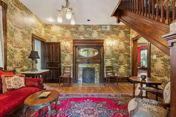 a living room with furniture a fireplace and a chandelier