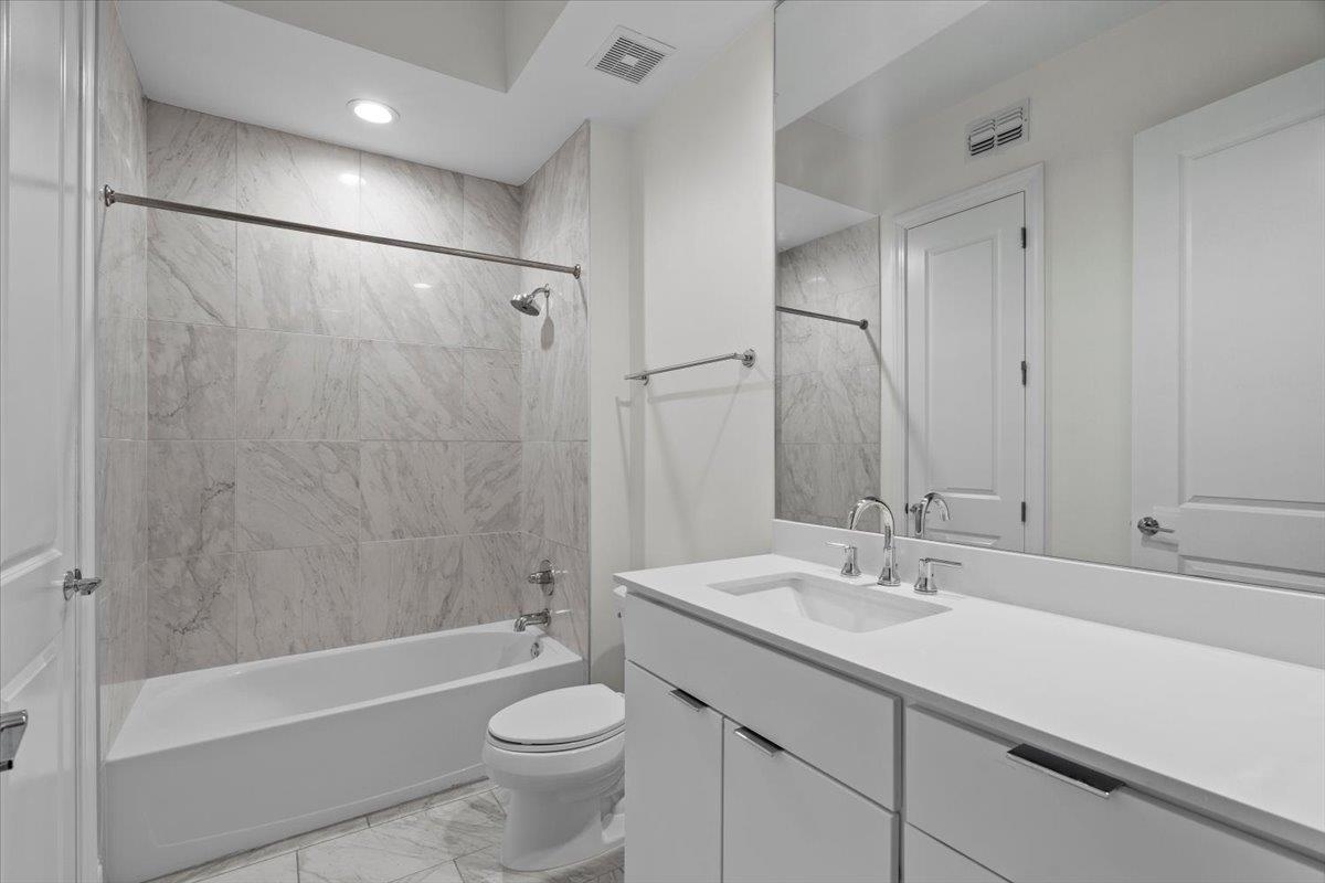 717 Riverside Drive, Unit 906 Memphis, TN 38103 - Photo 14 of 24 Full bathroom featuring visible vents, toilet, marble finish floor, and shower combination