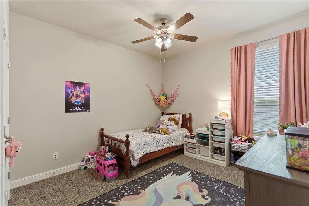 5621 Round Hl Road Denton, TX 76210 - Photo 21 of 27 a bedroom with a bed and a chandelier