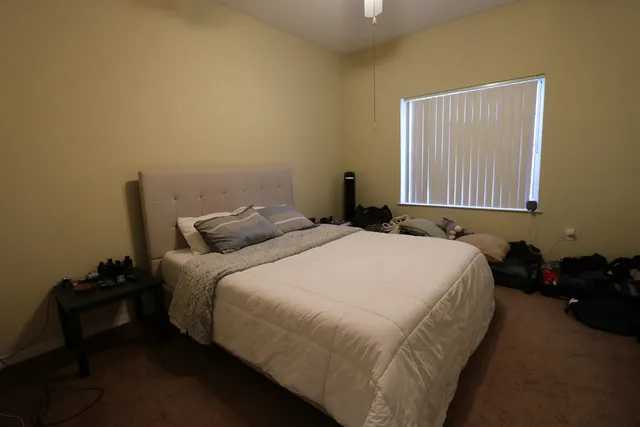 a bedroom with a bed and a window