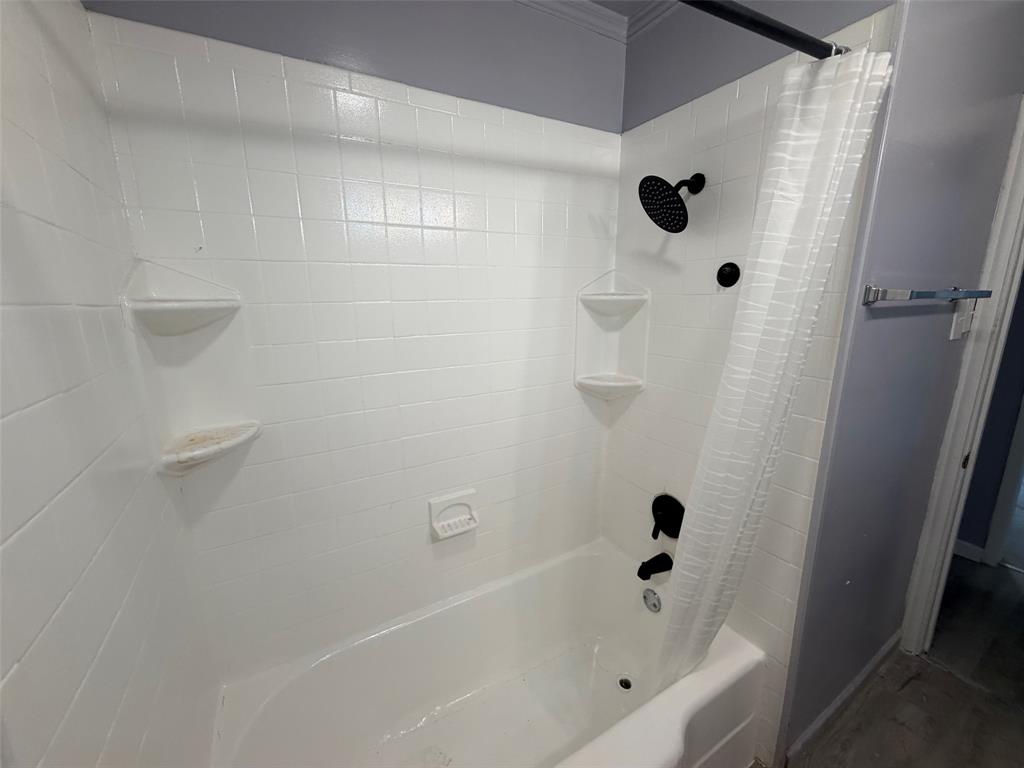 513 Shawnee Trace Grand Prairie, TX 75051 - Photo 8 of 32 Bathtub with white subway tile surround, matte black shower fixtures, and built-in corner shelving