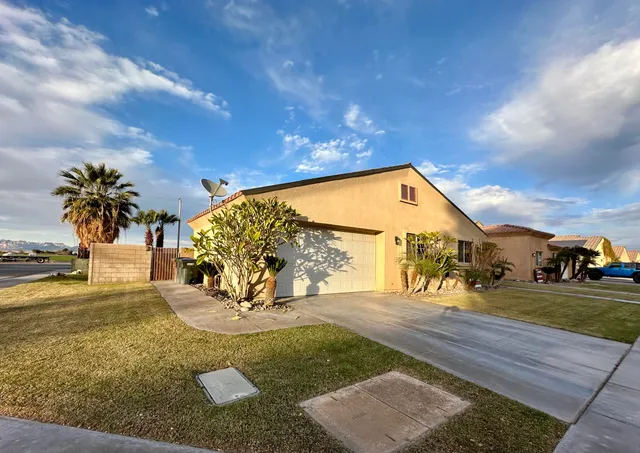 a kitchen with stainless steel appliances kitchen island granite countertop a table chairs and a refrigerator