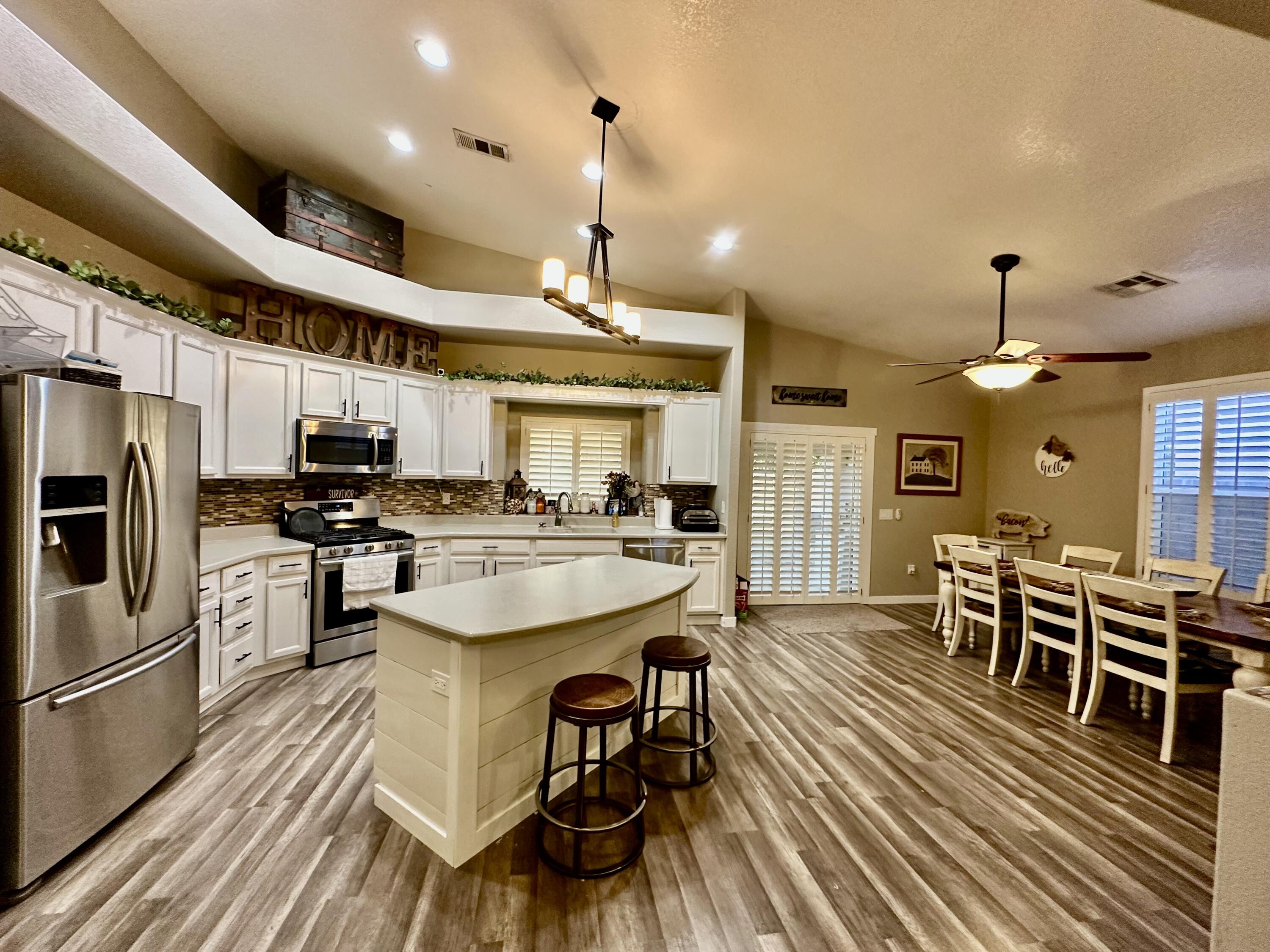 1461 Mesquite Road Blythe, CA 92225 - Photo 10 of 30 a kitchen with stainless steel appliances kitchen island granite countertop a table chairs and a refrigerator